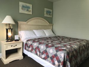 A bedroom with a bed and a lamp