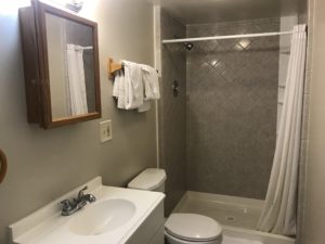 A bathroom with an open shower curtain