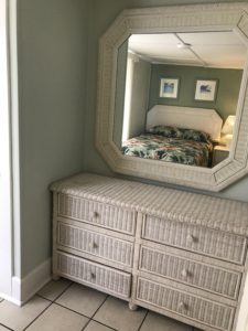 An eight-sided mirror above a white dresser