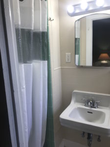 A shower curtain beside a mirror and sink