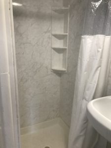 A bathtub with a white shower curtain